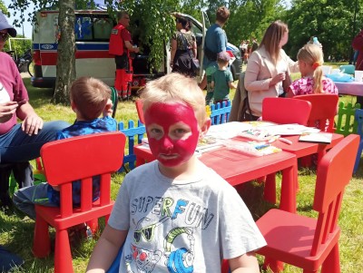 Dzieci przy stolikach oczekują malowania twarzy